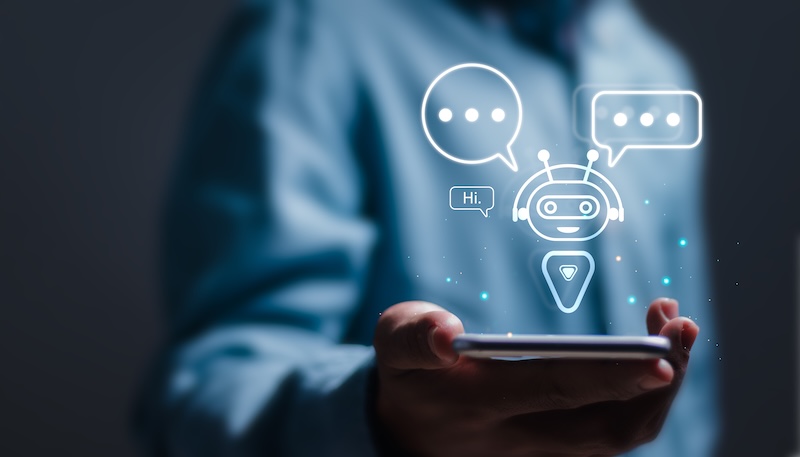 Man som håller i en telefon och använder en Chatbot