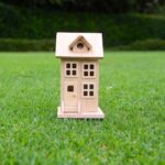 Litet trähus på gräsmatta - symboliserar attefallshus