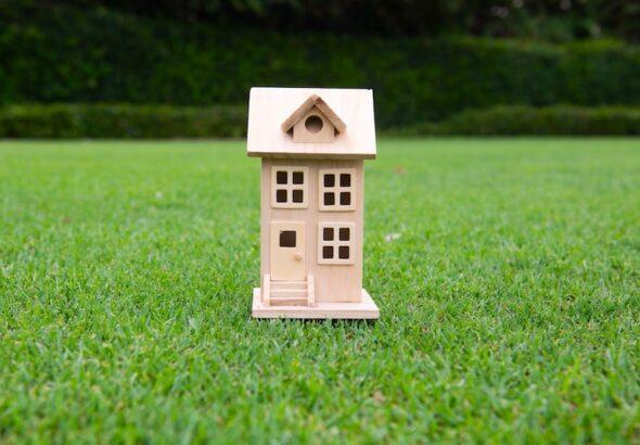 Litet trähus på gräsmatta - symboliserar attefallshus